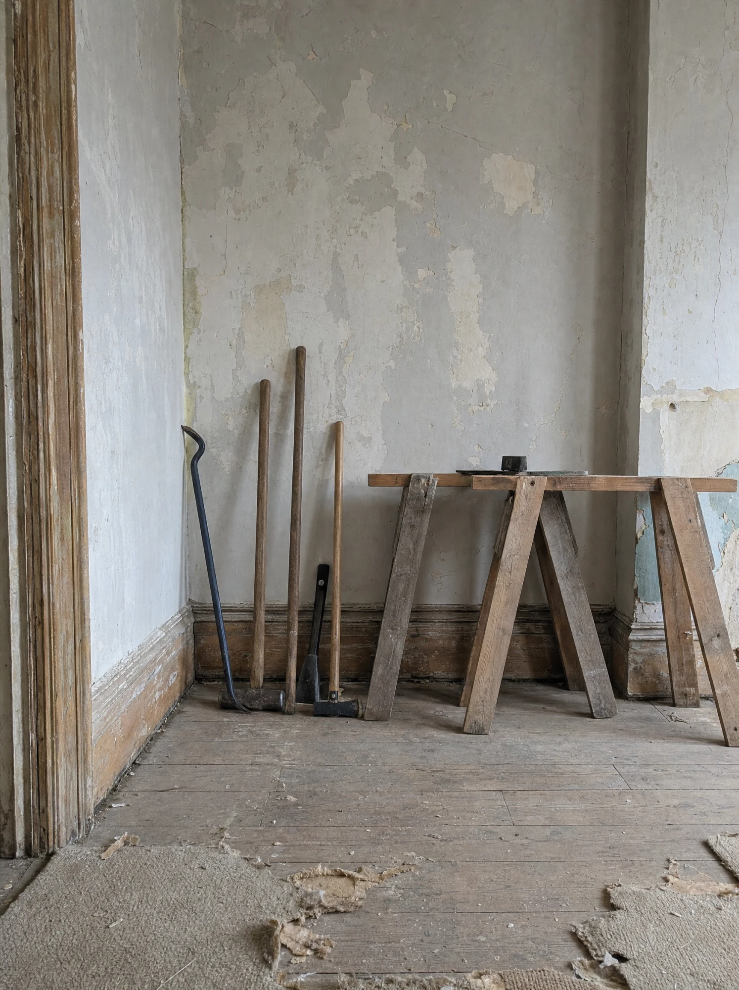 Restoration underway — tools against stripped plaster in the parlor corner